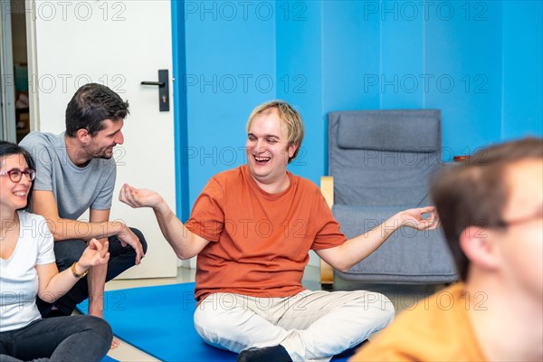 Instructor and disabled man smiling and talking during yoga class