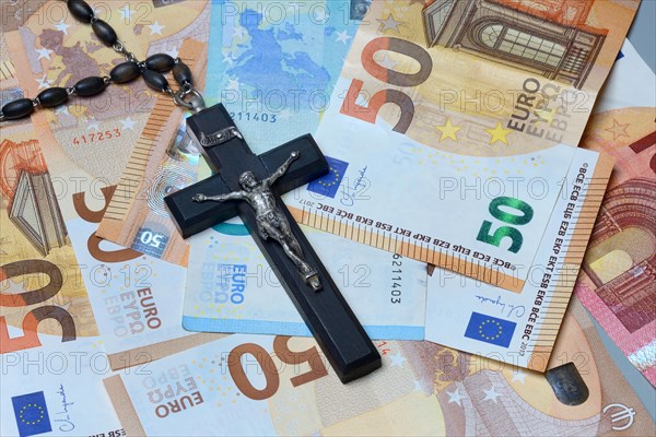 Crucifix and banknotes, church and money, church tax