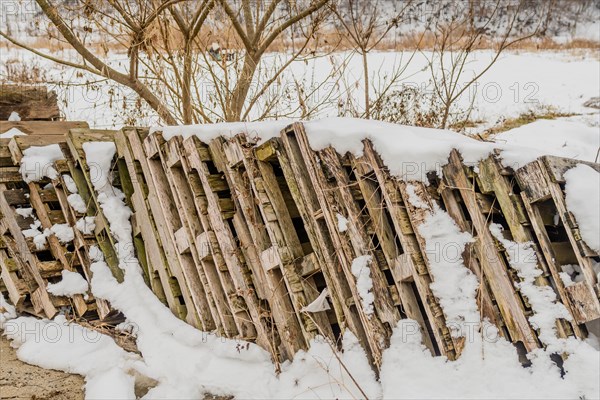 A decaying wooden fence partially covered with snow, in South Korea