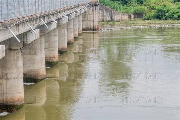 A sturdy concrete bridge spans across a wide river, reflected on the water's surface, in South Korea