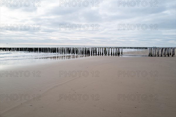 Sandy beach with a series of breakwaters that reach into the sea