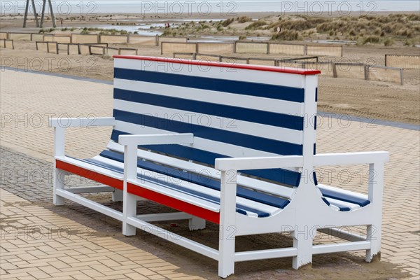 An empty, colourfully striped beach chair on the beach promenade, Zeebrugge, Flanders, Belgium, Europe