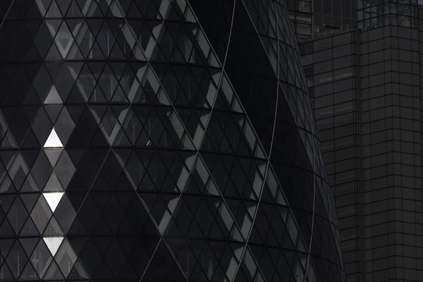 The Gherkin skyscraper building close up of window details with sunlight illuminating three triangle windows, City of London, England, United Kingdom, Europe