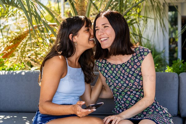 Beautiful woman whispering a secret to her best friend