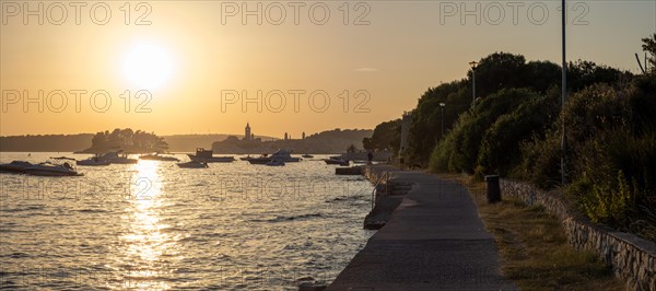 Promenade path, evening sun over Rab, town of Rab, island of Rab, Kvarner Gulf Bay, Croatia, Europe