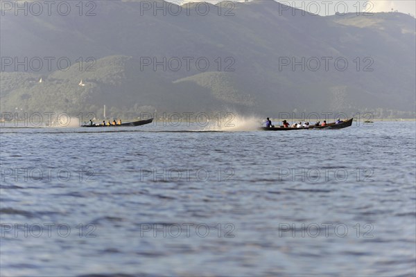 Motorboat travelling at high speed on a lake, mountains in the background, Inle Lake, Myanmar, Asia