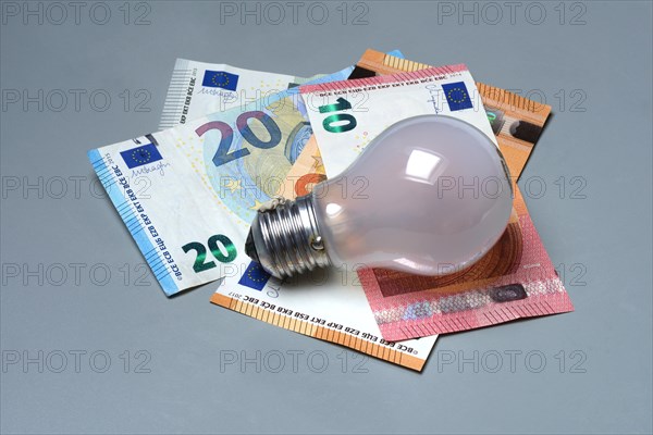 Banknotes and light bulbs, electricity costs