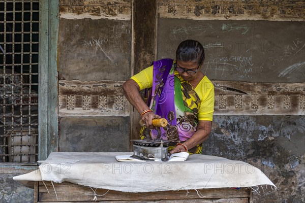 Woman flat iron cloth with a very old Unesco site, Ahmedabad, Gujarat, India, Asia