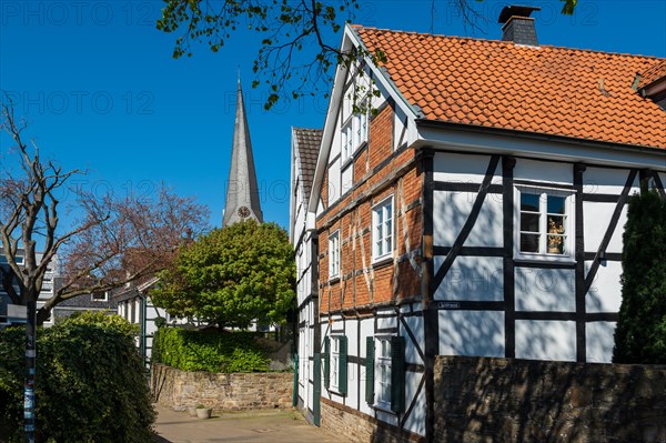 Traditional half-timbered house with church tower in the background on a sunny spring day, Old Town, Hattingen, Ennepe-Ruhr district, Ruhr area, North Rhine-Westphalia