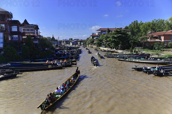 Lively river scene with boats and cityscape in the background, Pindaya, Inle Lake, Myanmar, Asia