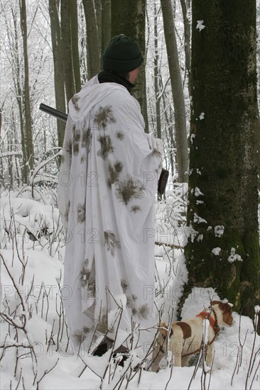 Hunter in winter with snow shirt and hunting dog Jack Russell Terrier, Allgaeu, Bavaria, Germany, Europe