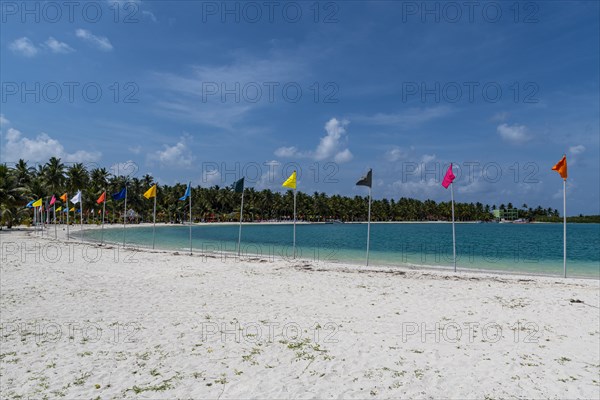 White sand beach with many flags, Bangaram island, Lakshadweep archipelago, Union territory of India