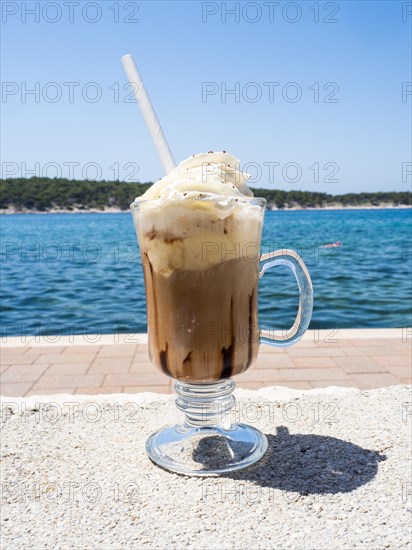 Iced coffee with whipped cream, the sea in the background, Rab Island, Kvarner Gulf Bay, Croatia, Europe