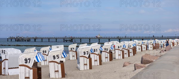 White beach chairs on the beach, behind the pier in Kuehlungsborn, Mecklenburg-Vorpommern, Germany, Europe