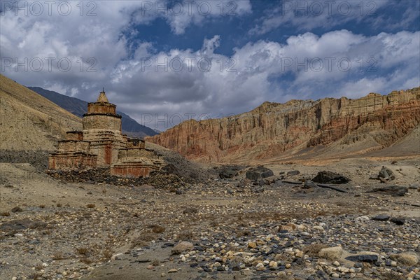 Colourfully painted Buddhist stupa, in a eroded mountain landscape, Kingdom of Mustang, Nepal, Asia