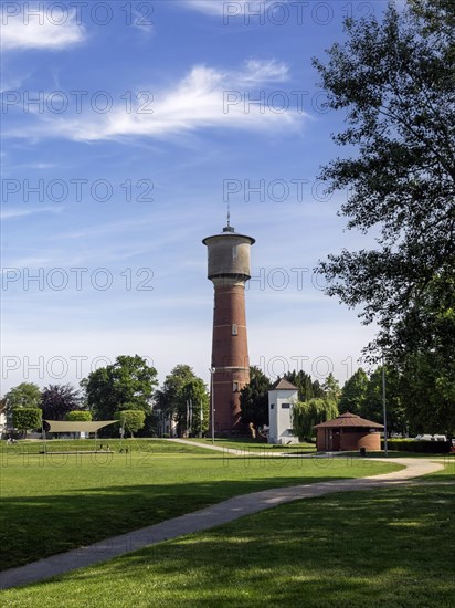 Brick water tower stands on a green lawn under a clear blue sky, Ladenburg, Baden-Wuerttemberg, Germany, Europe