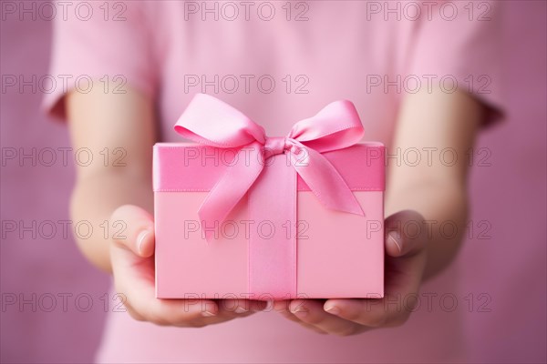 Girl child's hands holding pink gift box. Mother's day concept. KI generiert, generiert AI generated