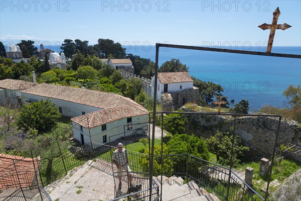 View of a religious site overlooking the sea, a person stands at the railing, view from the vantage point to the Byzantine fortress with nunnery, Holy Monastery of Timi Prodromos, Koroni, Pylos-Nestor, Messinia, Peloponnese, Greece, Europe