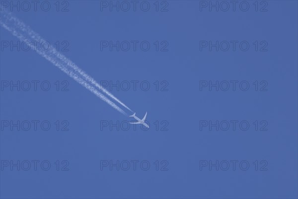 Jet aircraft in flight with a contrail or vapour trail behind in the sky, England, United Kingdom, Europe