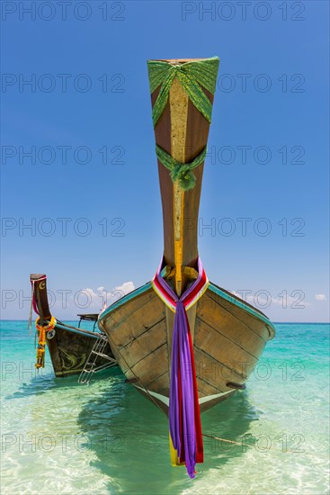 Longtail boat, fishing boat, wooden boat, decorated, tradition, traditional, faith, cloth, colourful, bay, sea, ocean, Andaman Sea, tropical, tropical, island, water, beach, beach holiday, Caribbean, environment, clear, clear, clean, peaceful, picturesque, sea level, climate, travel, tourism, paradisiacal, beach holiday, sun, sunny, holiday, dream trip, holiday paradise, paradise, coastal landscape, nature, idyllic, turquoise, Siam, exotic, travel photo, sandy beach, Phi Phi Island, Thailand, Asia