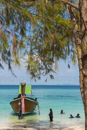 Muslim woman bathing on the beach, longtail boat, wooden boat, boat, decorated, tradition, traditional, faith, cloth, colourful, bay, sea, ocean, Andaman Sea, tropics, tropical, island, water, beach, beach holiday, Caribbean, environment, clear, clear, clean, peaceful, picturesque, climate, travel, tourism, paradisiacal, beach holiday, sun, sunny, holiday, paradise, coastal landscape, nature, idyllic, turquoise, Siam, exotic, travel photo, sandy beach, seascape, Phi Phi Island, Thailand, Asia
