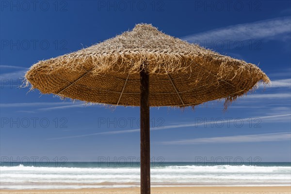 Parasol made of raffia on the beach with sea view, summer, sun, summer holiday, beach holiday, holiday, symbol, symbolic, holiday, travel, tourism, empty, nobody, blue sky, puristic, sea, Atlantic, ocean, holiday feeling, sunbathing, protection, sun protection, skin cancer, ozone, recreation, tourism, beach holiday, paradise, Caribbean, Caribbean, tropical, relaxation, exotic, heat, summer holidays, horizon, neutral