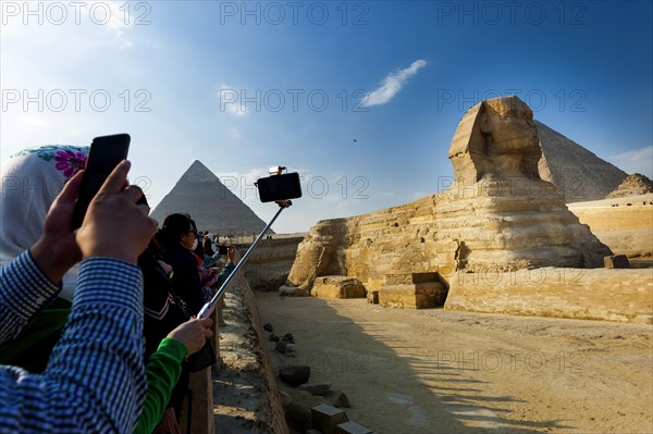 Tourists photograph the Sphinx of Giza, desert, wonder of the world, structure, sculpture, monument, architecture, building, ancient, history, earth history, human history, monument, world history, epoch, kingdom, pharaoh, limestone, monument, human head, lion body, attraction, famous, landmark, Cairo, Egypt, Africa