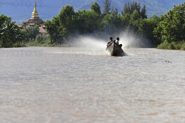 Person in a fast boat in front of a temple on the river, Inle Lake, Myanmar, Asia