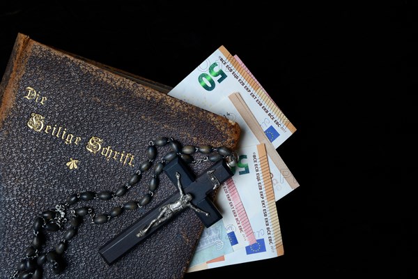 Bible, crucifix and banknotes, church and money, church tax