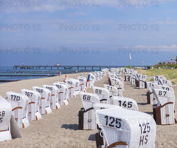 White beach chairs on the beach, behind the pier in Kuehlungsborn, Mecklenburg-Vorpommern, Germany, Europe