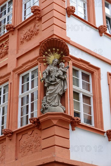 Baroque statue on a terracotta-coloured house facade with golden rays, Heidelberg, Baden-Wuerttemberg, Germany, Europe