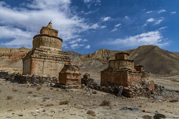 Colourfully painted Buddhist stupa, in a eroded mountain landscape, Kingdom of Mustang, Nepal, Asia