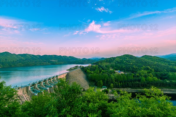 Panoramic view of a dam on a river with mountains at sunset, in South Korea
