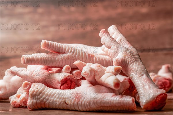 Pile of clean chicken feet on a wooden background and copy space