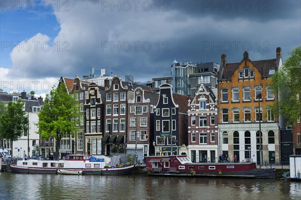 View of the Amstel with typical canal houses, boat, facade, house, property, downtown, centre, old town, building, typical, travel, city trip, tourism, big city, urban, world heritage site, canal, city centre, city view, Amsterdam, Holland, Netherlands