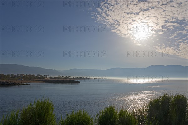 A peaceful sunrise over a coastal landscape with clouds in the sky and calm sea, mouth of the river Pamisos, Messini, Messinia, Peloponnese, Greece Motorhome drives over a bridge, Bouka Beach, Messini, Messinia, Peloponnese, Greece, Europe