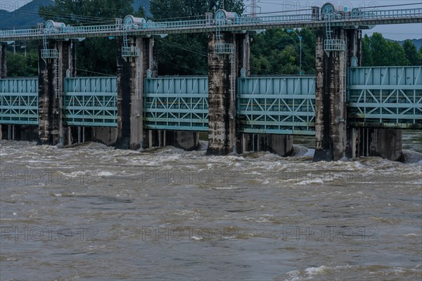 Dam with water surging through open floodgates after torrential monsoon rains in Daejeon South Korea