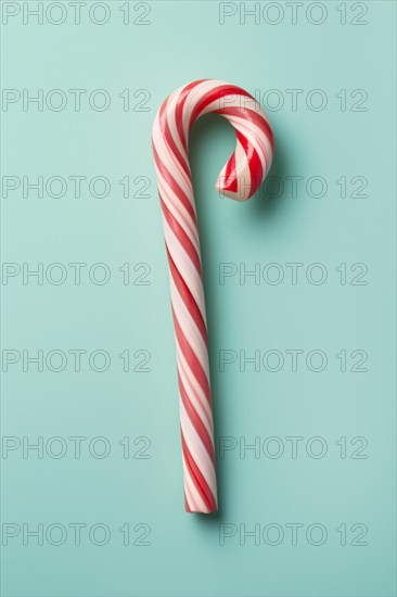 SIngle red and white candy cane on blue background. KI generiert, generiert AI generated