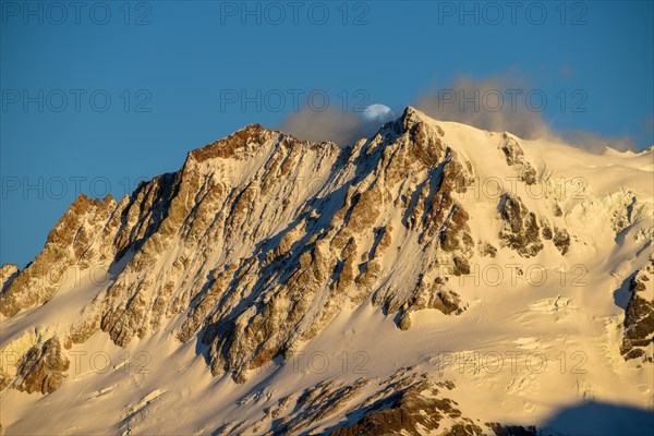 The snow-covered summit of Cerro Hermoso at sunrise with the moon, Perito Moreno National Park, Patagonia, Argentina, South America