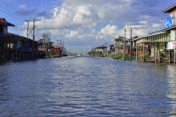 Village on stilts along a quiet waterway, Inle Lake, Myanmar, Asia