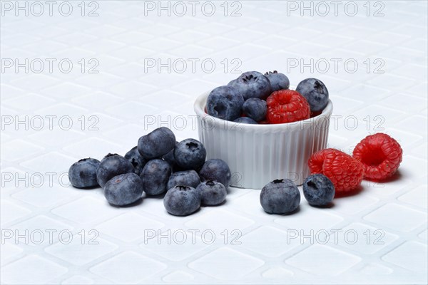 Blueberries in small bowls, raspberries