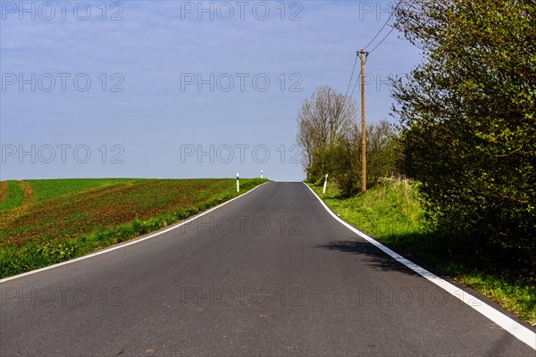 An empty country road leads through a green landscape under a clear blue sky, Nordbahntrasse, Elberfeld, Wuppertal, Bergisches Land, North Rhine-Westphalia