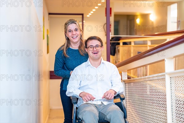 Happy portrait of a caregiver and man with down syndrome on wheelchair