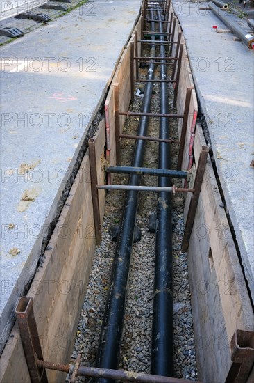 An open excavation pit with pipework and construction work for infrastructure