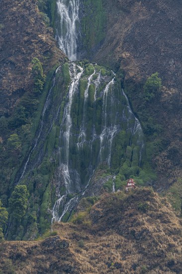 Little stupa undeaneath a huge waterfall, along the highway to Jomsom, Nepal, Asia