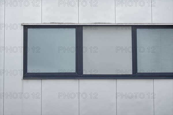Large window on a modern building facade with blue window sills