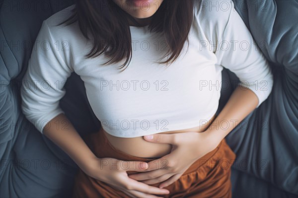 Woman in pain with stomach ache or menstrual cramps holding stomach with hands. KI generiert, generiert AI generated
