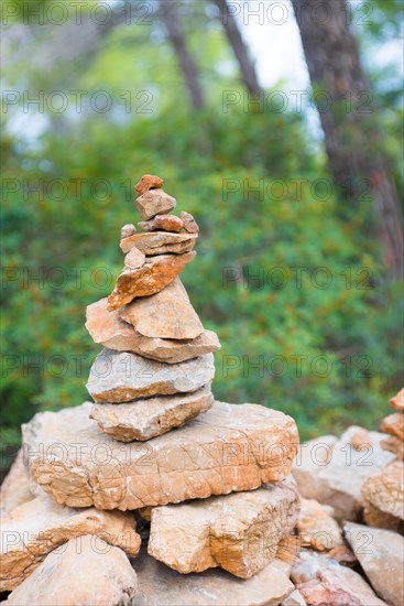 Carefully stacked, slightly red stones form a stone figure, cairn, waymark, marker in the forest, hiking trail from Sant Elm to the old watchtower Torre Cala Basset, balance, Mediterranean, Serra de Tramuntana, Mediterranean island Majorca, Spain, Europe