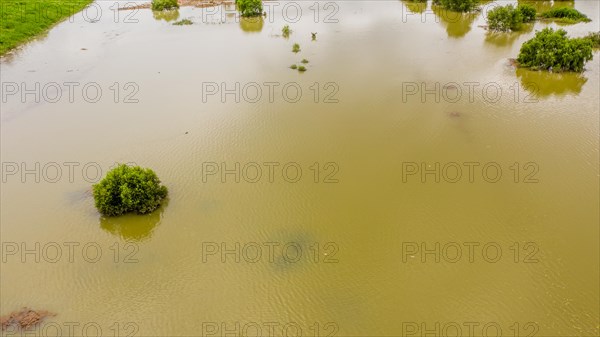 An aerial view of a landscape with greenery partially submerged in floodwaters, in South Korea