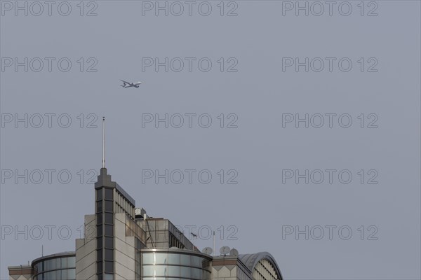 Airbus aircraft in flight over a city skyscraper building, London, England, United Kingdom, Europe